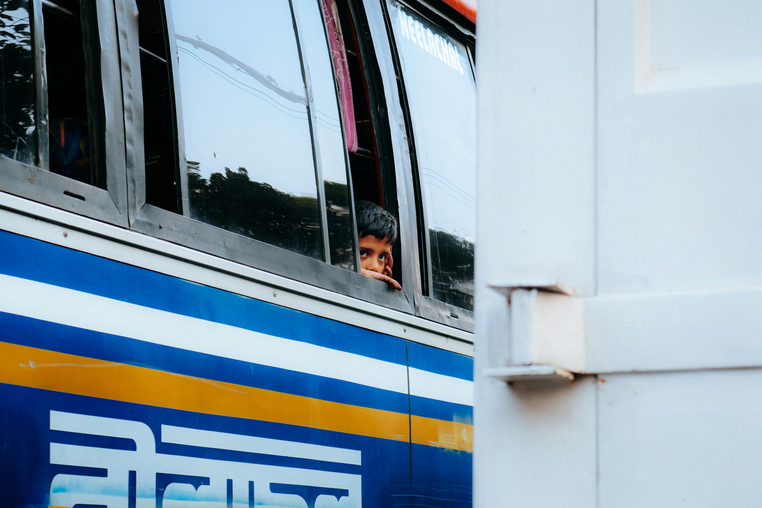 A young boy gazes out of a bus window on the streets of Dhaka, Bangladesh.