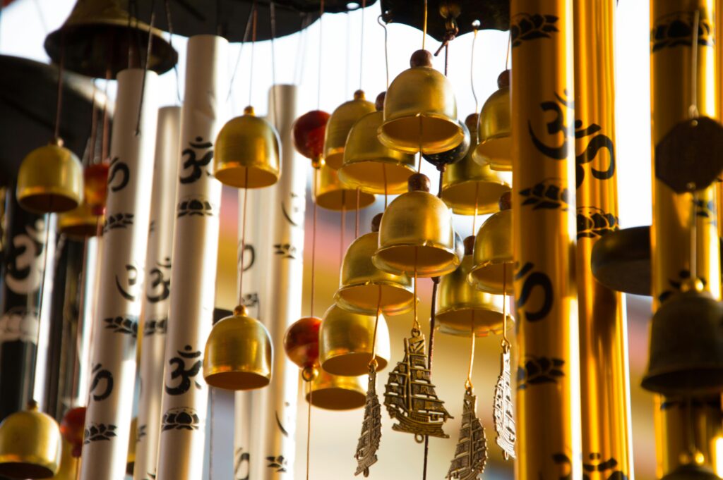 pexels-photo-2221515-2221515 Close-up of intricately designed golden wind chimes featuring Om symbols, creating a serene ambiance.